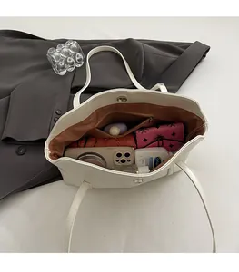 Top view of white PU tote bag interior showing large capacity with daily essentials