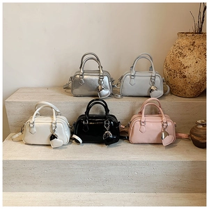 Collection of chic boston bags in silver and pastel colors with heart charms on display