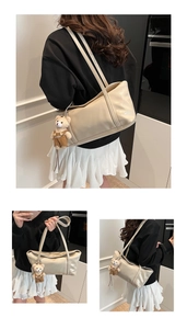 Dettaglio della borsa a spalla beige in vernice con un simpatico ciondolo a orsetto