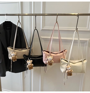 Detail of four glossy tote bags in beige, black, pink and cream with cute bear charms