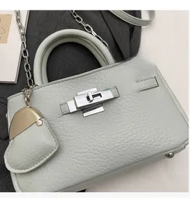 Close-up of celadon green leather bucket bag with silver metal lock and chain strap