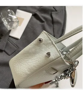 Detail of mint green bucket bag featuring silver hardware and textured leather finish