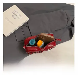 Vue intérieure du sac à bandoulière en cuir verni rouge foncé avec rangement pour maquillage
