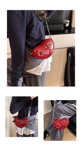 Détail du sac à bandoulière cœur rouge en cuir verni brillant avec chaîne en argent