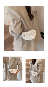 Détail du sac blanc porté épaule avec design en forme de cœur et chaîne argentée