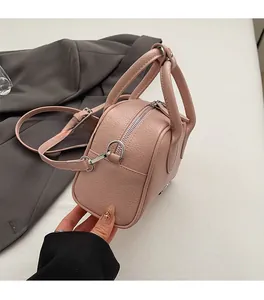 Close-up of pink lychee texture leather handbag featuring premium silver hardware accents