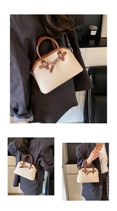 Détail du sac Boston tissé avec garniture en cuir contrasté et boucle métallique élégante