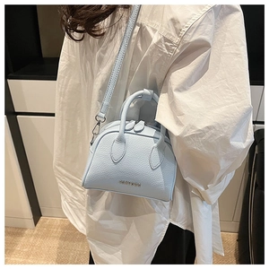 Close-up of light blue lychee pattern Boston bag with silver logo and crossbody strap