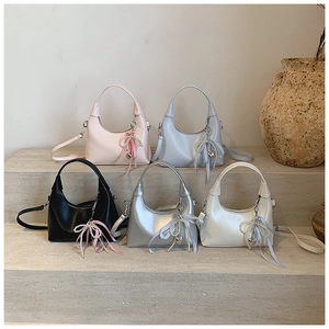 Fashionable bow hobo bag in five colors on stone steps with pearl heart charms