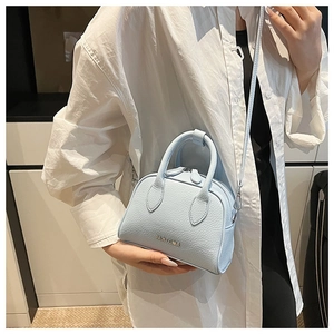 Close-up of light blue lychee pattern mini boston bag with metal logo and handle detail