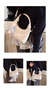 Detail view of a white crescent faux leather handbag with pearl and bow charm accessories