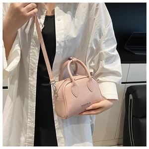 Detail view of pink lychee leather Boston bag featuring dual handles and silver logo