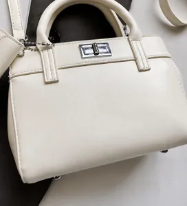 Detail of soft cream leather handbag with silver metallic twist lock and smooth texture