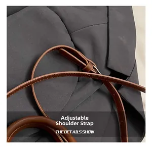 Détail de la bandoulière réglable en cuir avec boucle en métal sur un sac marron foncé