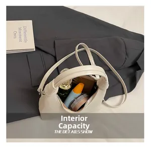 Internal capacity of cream-white leather handbag showing phone and makeup items
