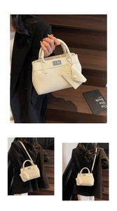 Detail of a creamy white handbag with a silver twist lock and mini envelope pouch