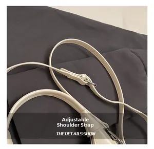 Detail of adjustable cream-white faux leather strap with polished silver metal buckle