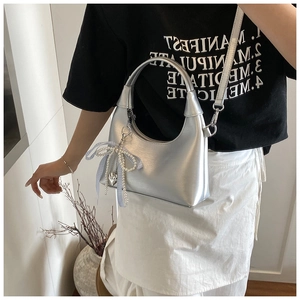 Sac hobo argenté avec breloque cœur perle vu de côté porté par un mannequin