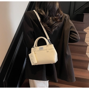 Detail of cream crossbody bag with silver hardware and mini coin pouch accessory