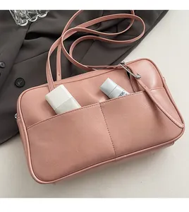 Detail van roze schoudertas met twee voorvakken voor cosmetica en zilverkleurige gesp