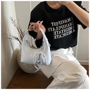 Détail du sac hobo bleu clair avec bandoulière en perles et ruban à carreaux
