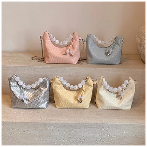 Détail de mini sacs tissés avec des poignées en perles élégantes et chaînes en métal