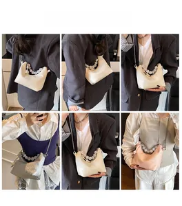 Détail du sac sous le bras plissé avec poignée en perles et fine bandoulière en métal