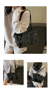 Détail du sac cabas en cuir ciré noir brillant avec une petite pochette assortie