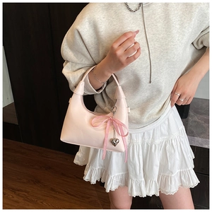 Sac à main rose demi-lune avec nœud à carreaux et pendentif en forme de cœur en détail
