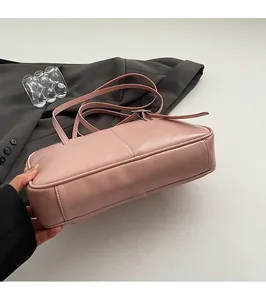 Detail van de duurzame platte bodem en fijne stiksels op de roze leren schoudertas