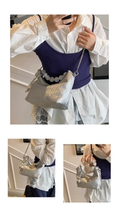 Détail du sac hobo tissé argenté avec poignée en perles décoratives et chaîne en métal