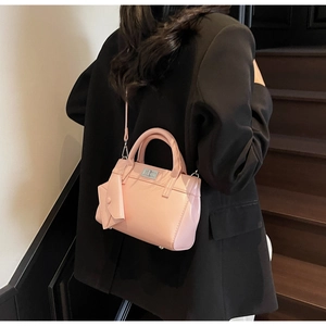 Detail of pink patent leather handbag with silver clasp and small envelope charm
