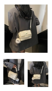 Nahaufnahme der geflochtenen Handtasche mit abnehmbarem Plüschbommel und Trageriemen