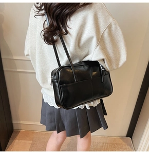 Zwarte kunstlederen schoudertas gedragen bij een casual outfit in Japanse schoolstijl