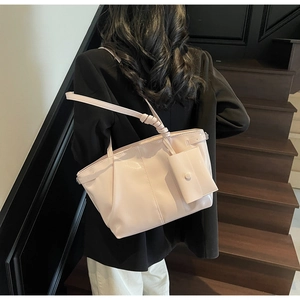 Vue détaillée d'un sac cabas beige brillant avec bandoulière nouée et mini pochette assortie