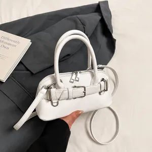 Detail of white faux leather handbag with lychee texture and silver metal buckle
