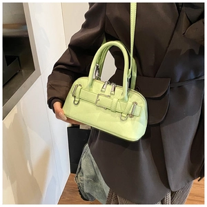Close-up of light green shell bag featuring silver hardware and decorative belt buckle