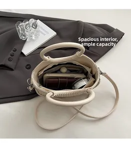 Internal view showing the storage capacity for phone and wallet in the beige handbag