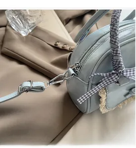 Detailopname van de lichtblauwe bowlingtas met kant en glanzende zilverkleurige hardware
