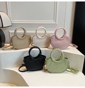 Collection of pleated half-moon handbags in five colors with circular handles and straps