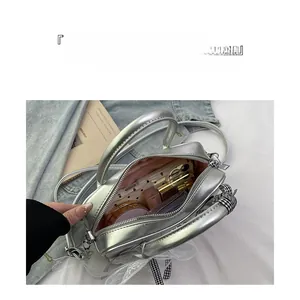 Detail of silver faux leather boston bag showing spacious pink lining for essentials
