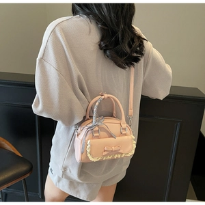 Detail of pink PU leather bowling bag with lace bow and plaid ribbon handle