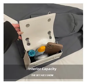 Top view of white leather crossbody bag interior showing phone and cosmetics capacity