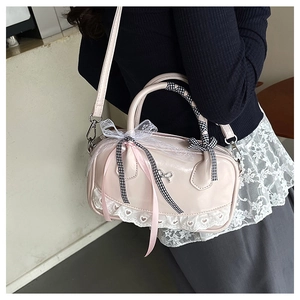 Detail of pink bowling bag with heart lace trim and ribbon bow on model side