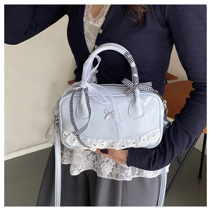 Detail of light blue bowling bag with metal bow and white lace trim in balletcore style