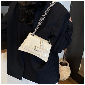 Détail du sac à bandoulière crème avec chaîne argentée et doubles boucles élégantes