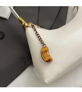 Nahaufnahme weiße Handtasche mit Litschi-Maserung, Goldkette und modischem Anhänger