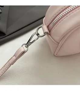 Détail des finitions argentées et des coutures sur le sac polochon en cuir rose