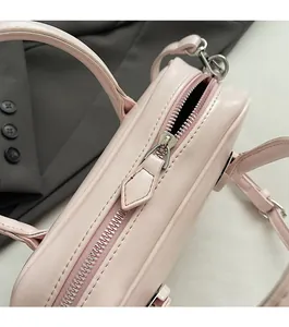 Détail de la fermeture éclair en métal et texture cuir du sac à main rose élégant
