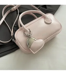 Vue détaillée du sac à main rectangulaire rose avec pendentif coeur et logo CLEAR K